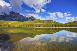 Frosty morning in the Rocky Mountains, Canada. Clear water Pyramid Lake reflects the clouds and