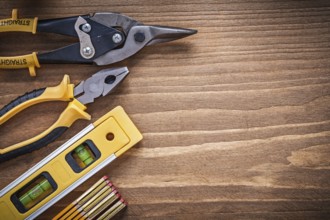 Pliers tin snips construction level wooden meter on wood board