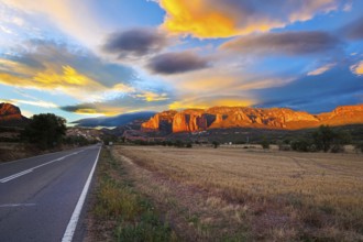 Red sunset. The magnificent Mallets of Riglos cliffs. Scenic paved highway. Romantic trip to Spain.
