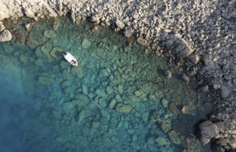 Drone aerial photograph of Cape Greko peninsula. Boat in the ocean. Turquoise ocean water