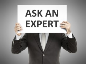 A business man holding a paper in front of his face with the text ask an expert