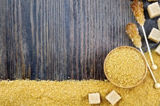 Sugar brown granules in a bowl, cubes and crystals on a stick in the form of a frame on the