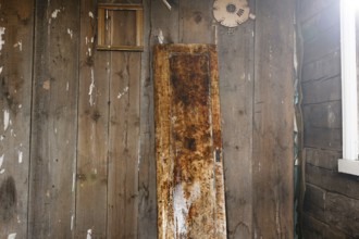 Rustic wooden door against an aged wooden wall indoors