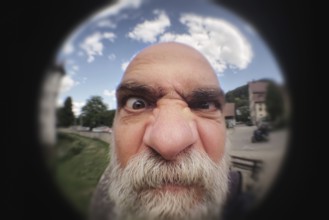 An image of an angry man looking to a peephole door
