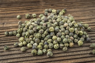 Dried spices green pepper. Peppercorn on dark rustic wooden background