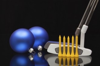 Christmas decoration and two golf putters on a glass desk