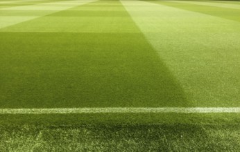An empty football stadium with green grass
