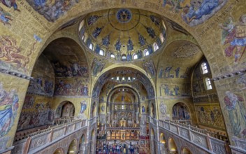 Upper view of a cathedral interior with vaulted ceilings adorned with gold mosaics and religious