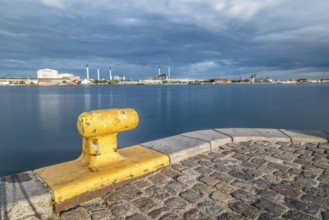 Scenic view of the skyline of Copenhagen at sunset from dock with yellow bollard on foreground