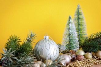 A Christmas decoration glass balls with fir trees on yellow background