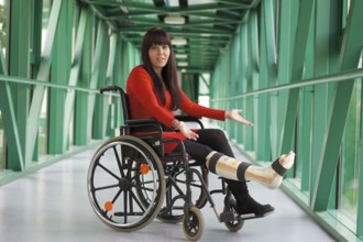 Young woman with plaster leg sits in a wheelchair Austria