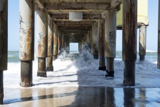 Dynamic ocean waves flowing under the sturdy pier