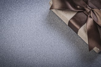 Packaged present with brown bow on grey background celebrations concept