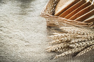 Wicker basket sliced toast bread rye ears on textured sacking background
