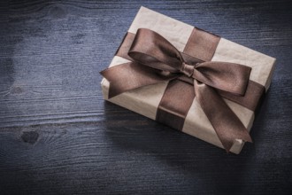 Gift box-container with bow on vintage wooden board