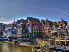 An atmospheric water scene with beautiful old half-timbered houses along the river on a sunny day,