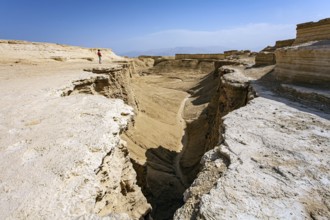 Woman tourist in a red sweater admires the landscape. The Judean Desert. Israel. Interesting walk