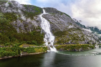 Western Norway. Langfossen cascade waterfall on the Vaule river. Passes through the highway. The