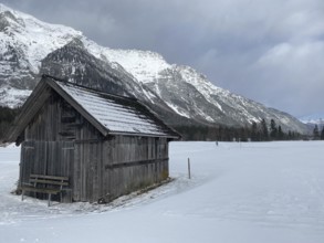 Winter mountains landscape with wooden barn and dramatic sky, Leutasch, Austria