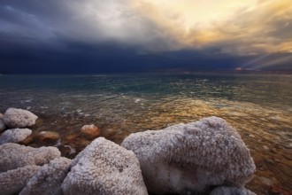Coast of the Dead Sea in Israel in a spring thunder-storm. The coastal stones covered by salty