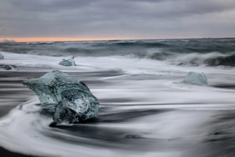 Ice floes on the black sea sand and the coast Jokulsarlon