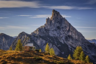 Sass de Stria mountain in the light of the setting sun near Passo Falzarego with cabin lodge
