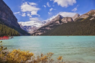 Lake Louise on a beautiful sunny day. The lake is surrounded by mountains, glaciers and pine