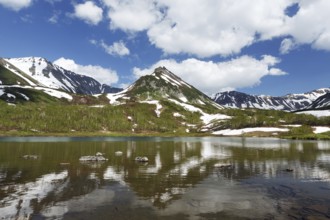 Summer landscape of Kamchatka: view of Mountain Range Vachkazhets and clouds in blue sky,