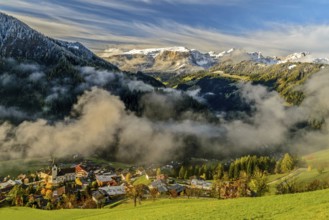 Autumn landscape with colorful trees and snowy mountains in the background in Dolomites