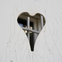 Closed white shutter with a heart-shaped opening