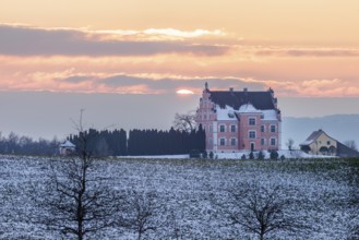 A castle in the middle of snow-covered fields at sunset with a cloudy sky, Freudental Castle,