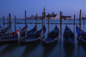 Venetian gondolas, boat dock at St Mark's Square, church of San Giorgio Maggiore in the background,