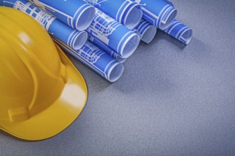 Hard hat blue construction drawings on grey background