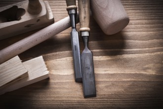 Wooden hammer stud planner flat chisels on wood board construction concept