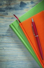 Notepads pen on wooden board office concept