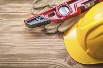 Building helmet protective gloves construction level on wooden board