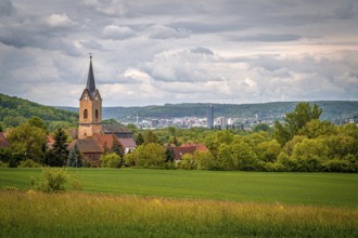 Church of Kunitz in the middle of a rural landscape with a view of the city of Jena, under a cloudy
