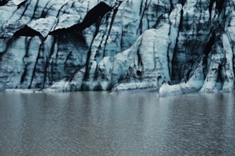 Blue glacier wall with striped pattern reflected on calm water, iceberg Iceland, glacier, snow, ice