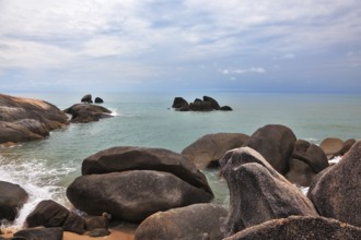 Picturesque coastal cliffs and subdued after a storm sea. Koh Samui