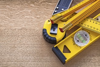 Wood oaken board with yellow objects of measurement construction concept