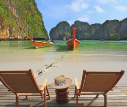 Two convenient comfortable guest sun loungers and a bedside table are worth on a wooden platform.