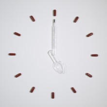 Time - Clock of twelve pills, medical thermometer and plastic spoon