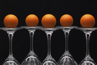 Five glasses of champagne with golf balls
