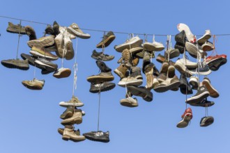 Shoes, boots, trainers, ... hanging on a rope in the air above the Grapengießerstraße medieval old