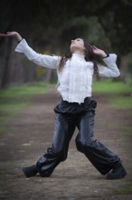 Young woman dancing outdoors. Dance performance in the park