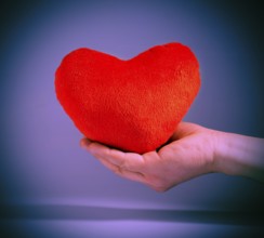Vintage look red plush heart. Hand holding red heart