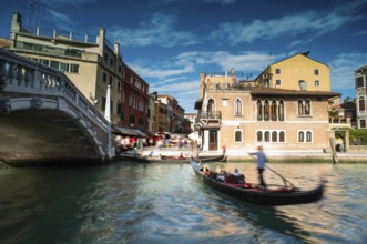 Ancient buildings and boats in the channel in Venice