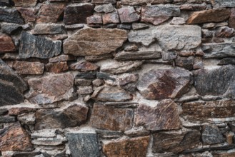Old stone wall at the castle ruins. Texture of old weathered medieval stone wall
