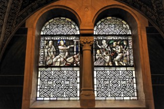Stained glass window with sacred scenes and filigree stained glass in a church wall, Bad Homburg v.
