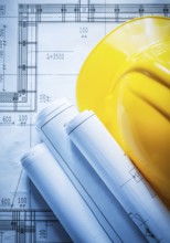 Building helmet rolled construction drawings on blueprint